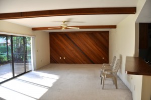 View of living room with the '80's' wood beams and funky wood wall.