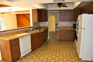 Old kitchen complete with bad linoleum, fake wood countertops and ugly cabinets.